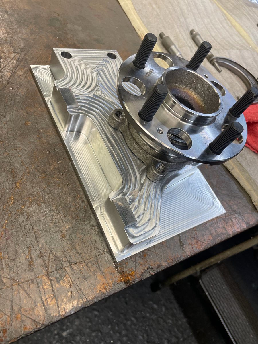Aluminum fixture plate machined with a wheel hub mounted on it