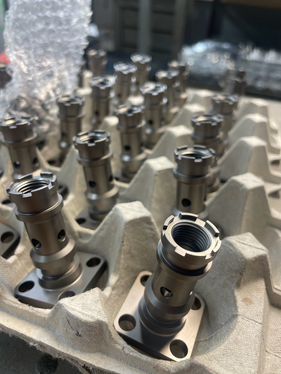 Titanium-colored valve bodies with square flanges in a tray