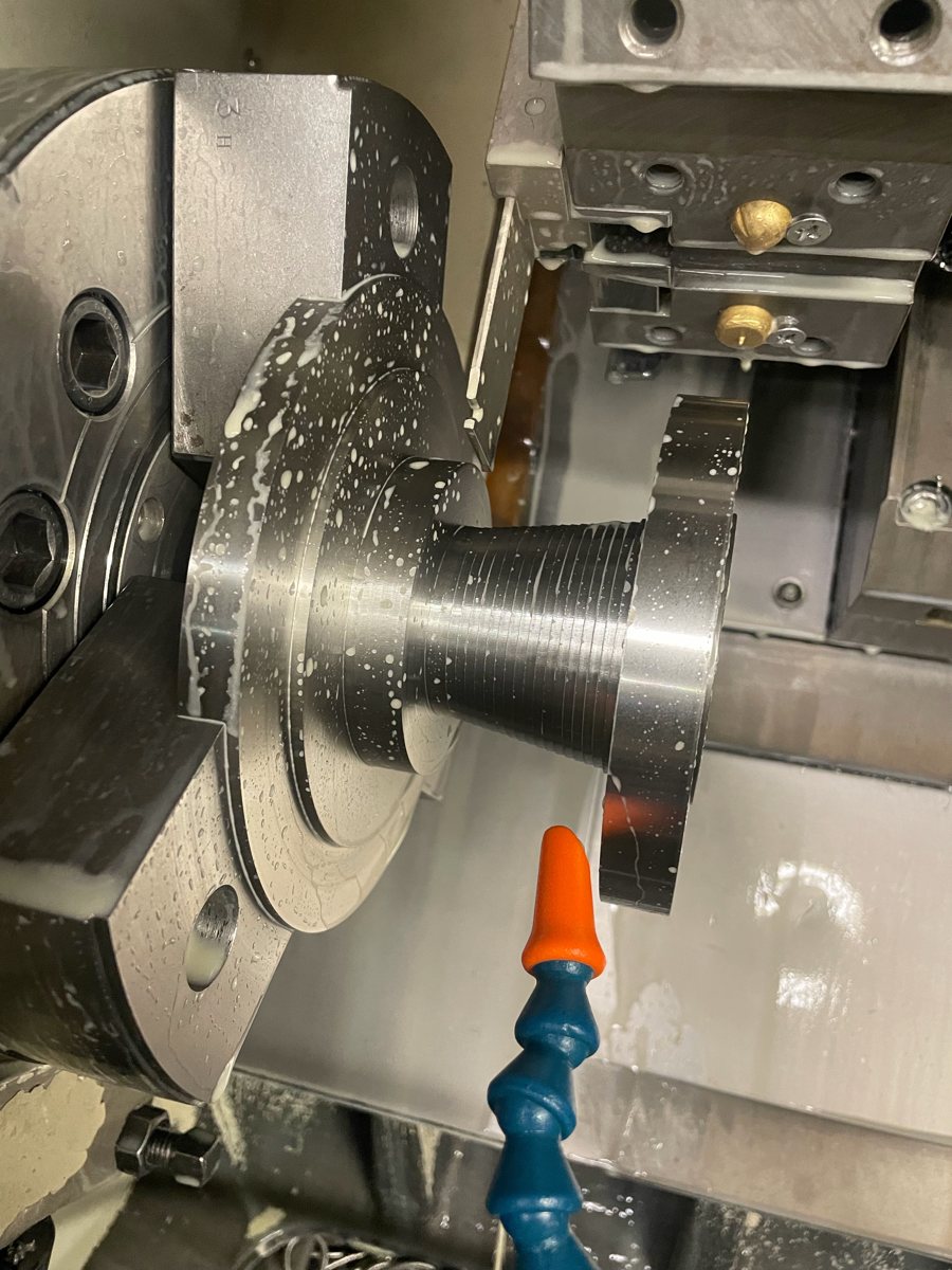 Threaded part held in a lathe chuck during turning